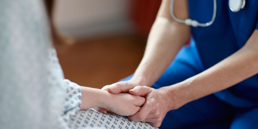 Cropped image of nurse holding patient's hand