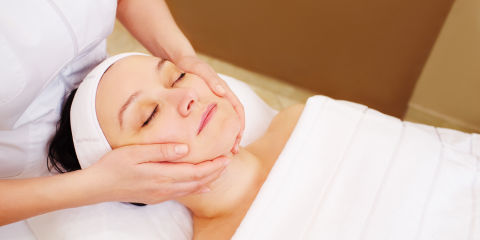 High Angle View Of Woman Receiving Facial Massage In Spa