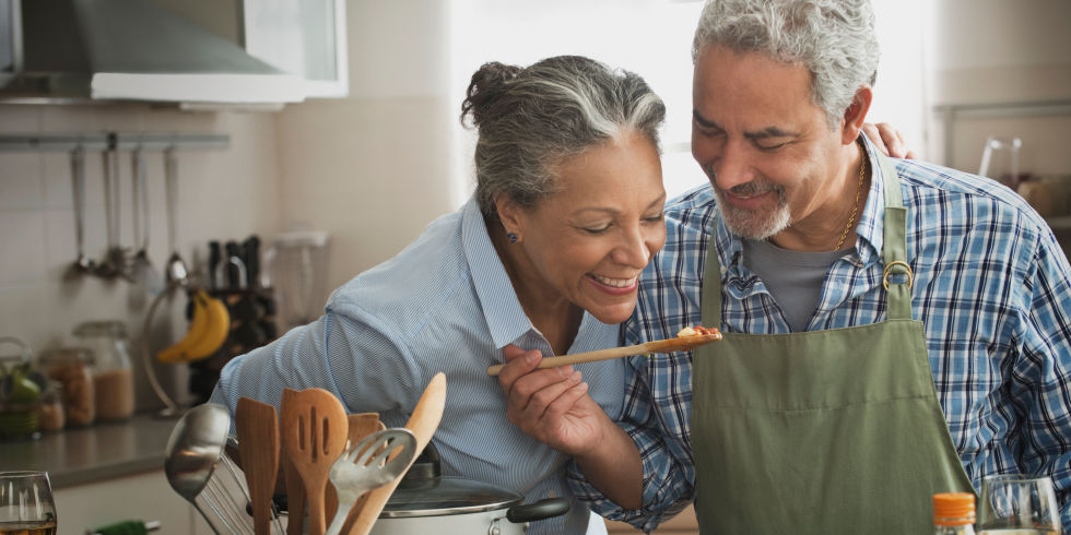 Senior couple cooking in kitchen happy